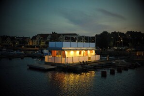 A waterfront building with a dock, a covered area, and a view of the water. - Unique Floating Retreat Sleeps 4 (Sölvesborg)