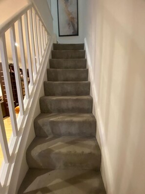 A carpeted staircase with white railings leading to a landing. - Sleeps7- South Kensington- Family Friendly (London)