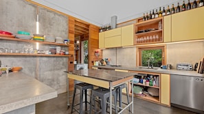 A modern kitchen with a bar area, stainless steel appliances, and a variety of kitchenware. - Old Lonnie Crigan RD (Point Lonsdale)