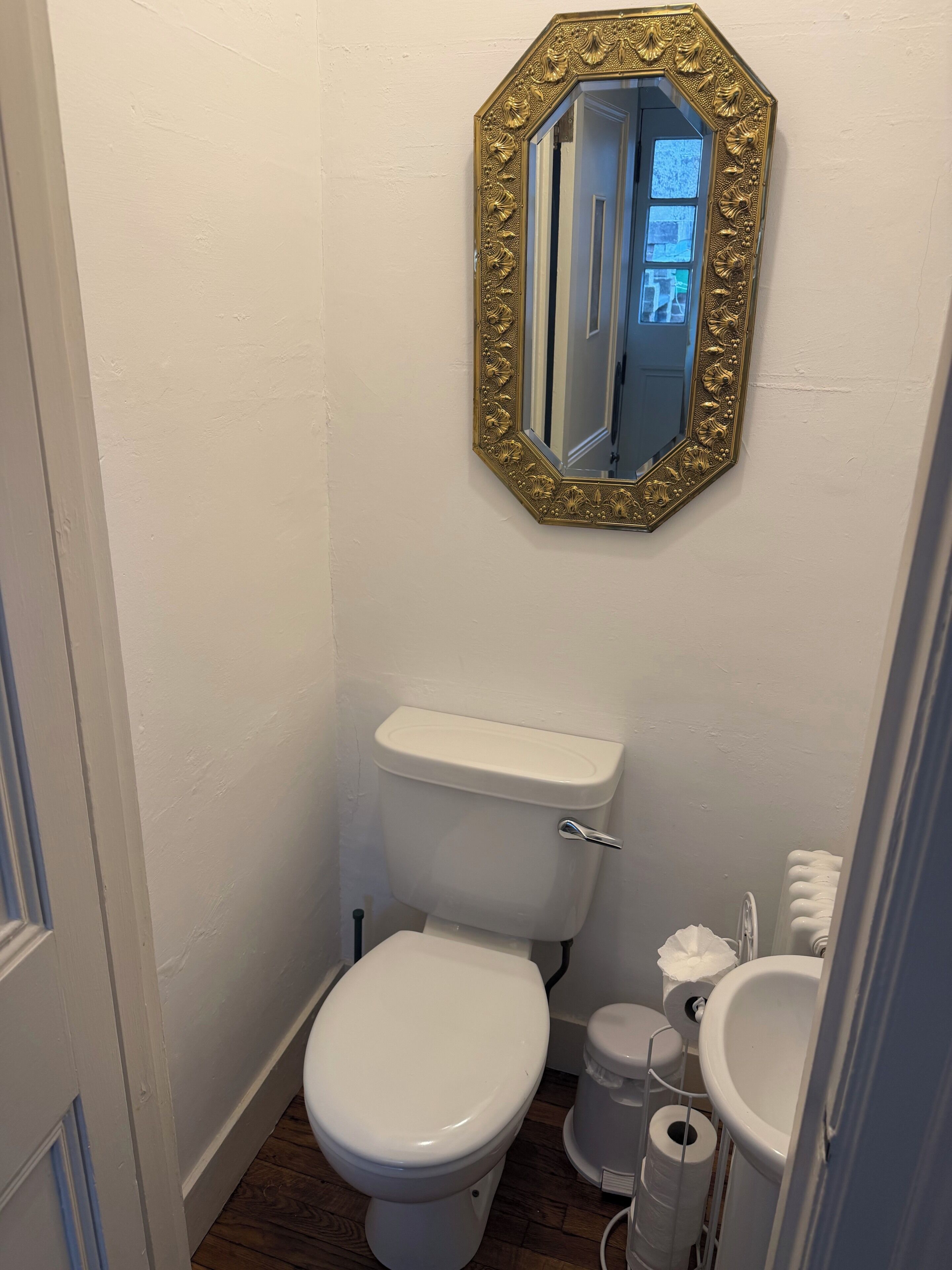 A bathroom with a toilet, a sink, and a mirror.