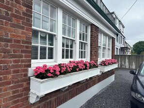 A residential building with white-framed windows and brick walls.