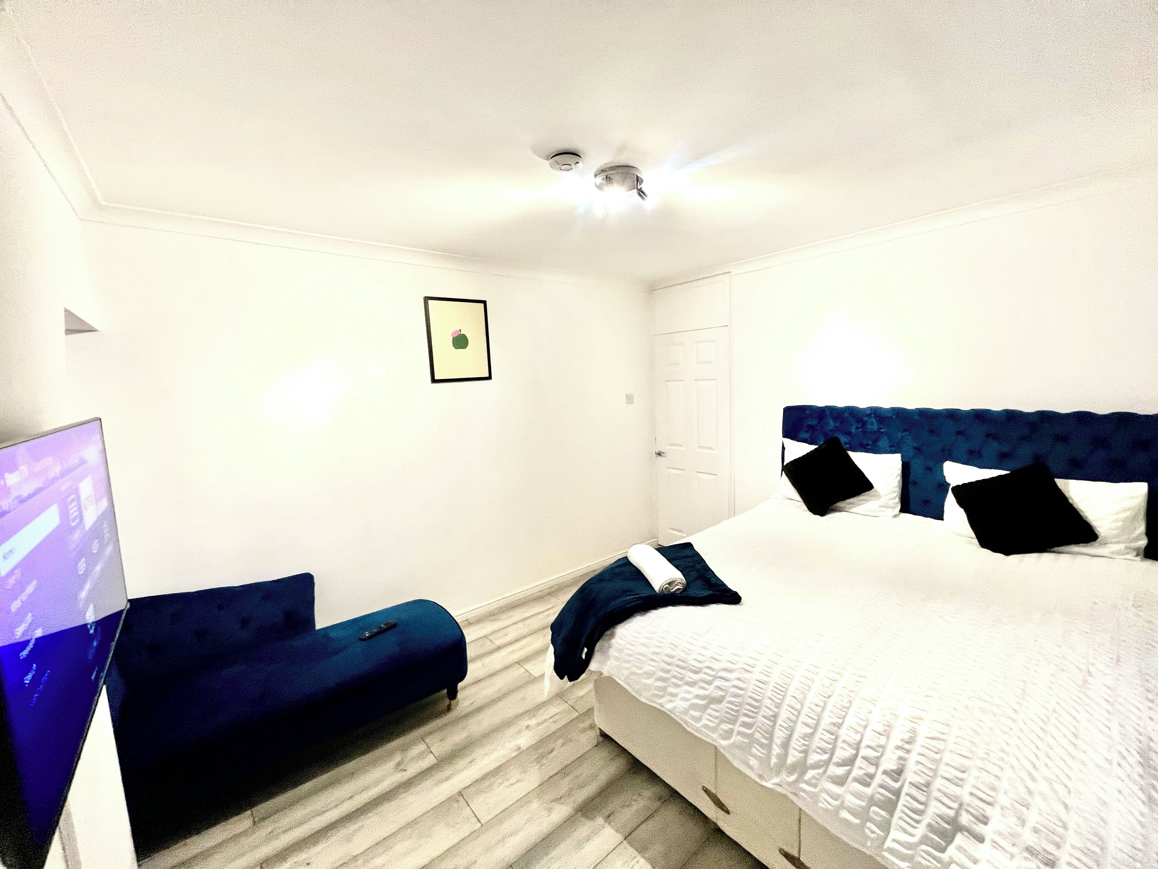 Ein Hotelzimmer mit Bett, Schreibtisch, Stuhl und Deckenventilator.