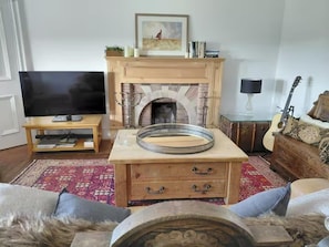 A living room with a fireplace, a television, a guitar, and a sofa. - Sleeps 15 8 Bed-near Royal Troon-ayrshire Coast (Prestwick)