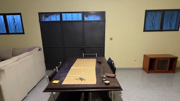 Una sala de conferencias con una larga mesa, sillas, un sofá y un mueble bajo.