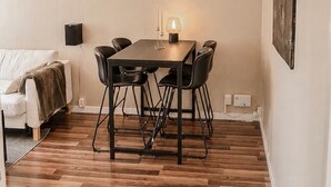 Et spiseområde med et bord, stole, en sofa og et billede på væggen.
