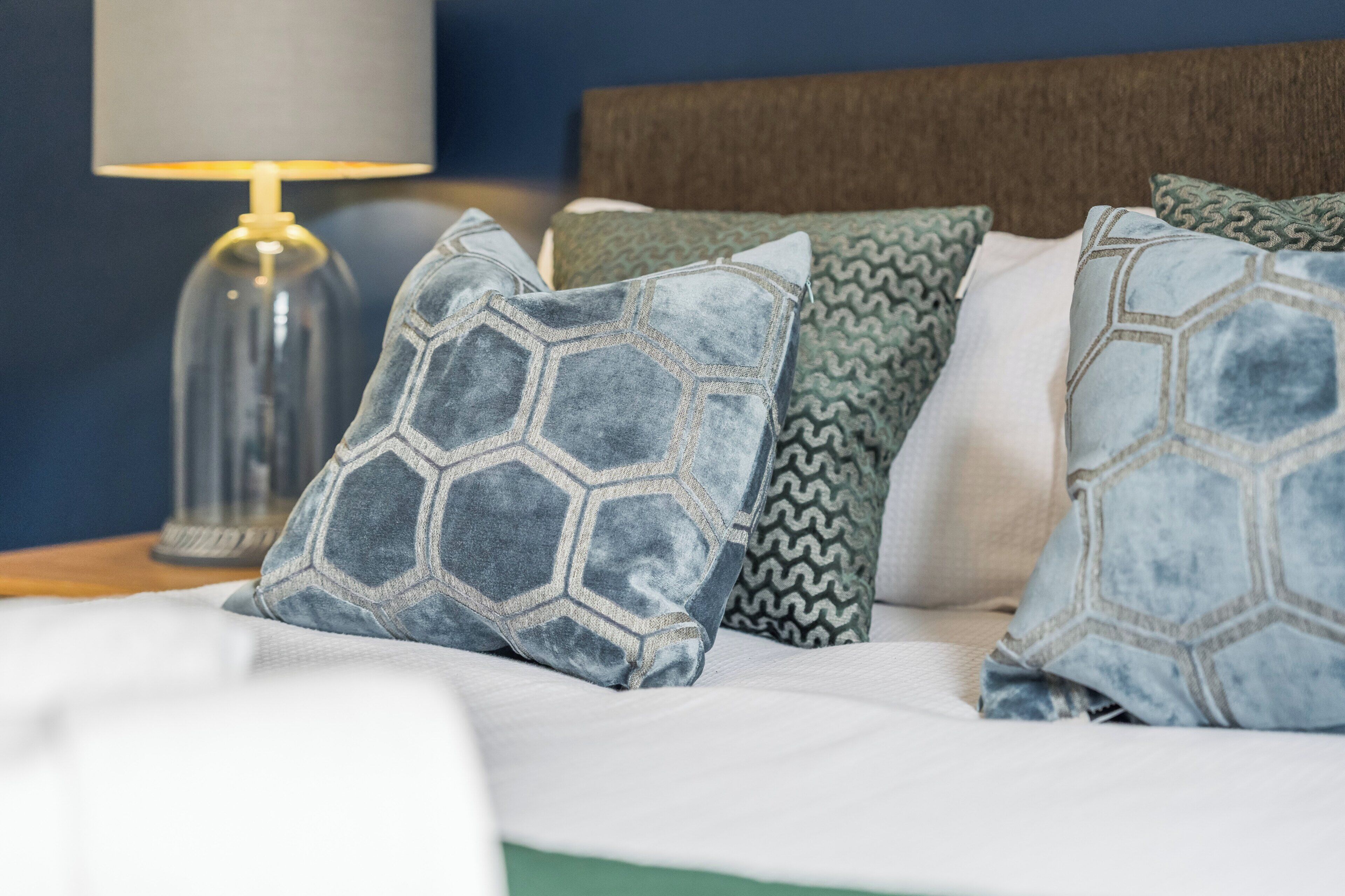 A bed with multiple pillows featuring geometric patterns.