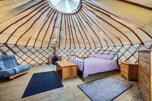 A yurt interior with a bed, seating area, and a small table. - Yurt Sleeps 2 - Bbq & Fire Pit - Dogs Welcome (Bodmin)