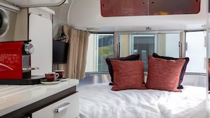 Une chambre à coucher avec un lit, une télévision, une table basse et une fenêtre.