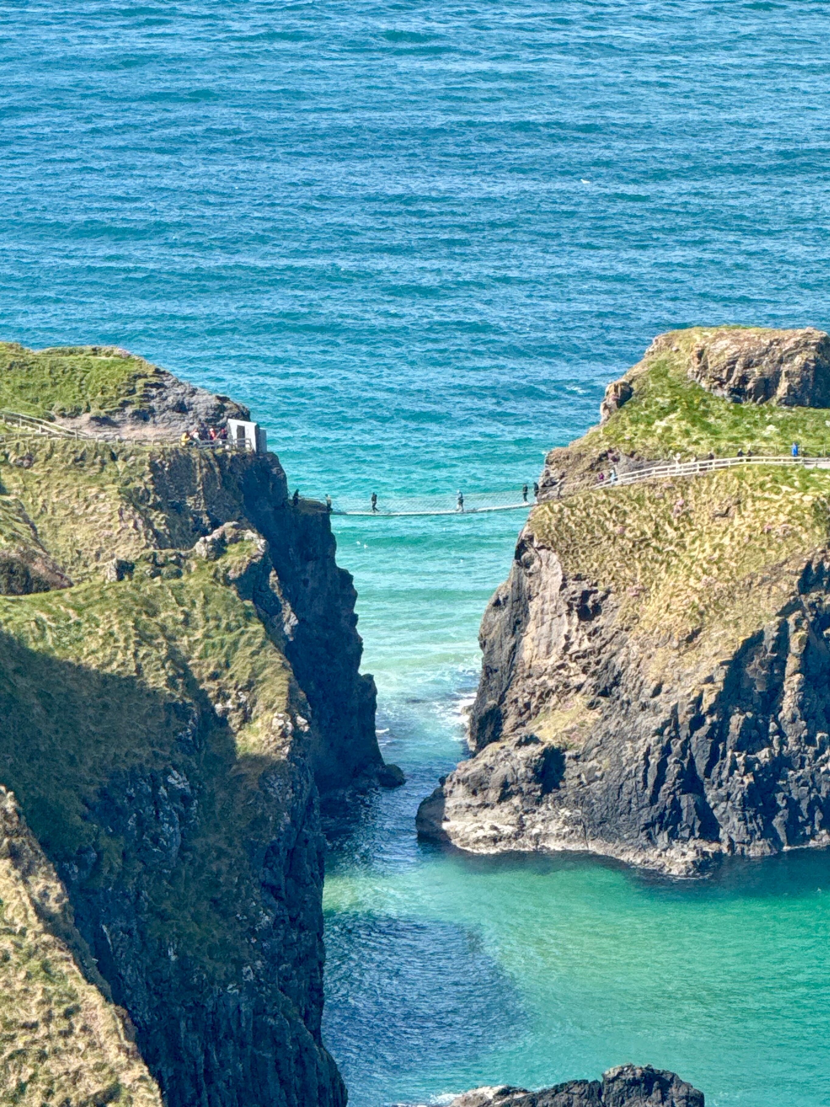 Un paisaje costero con acantilados rocosos y un mar azul cristalino.