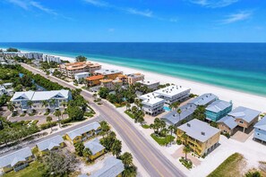 An aerial view of a coastal resort area with beachfront properties, roads, and greenery. - NEW! Beachfront 2BR + Pool + Walk to Beach (Indian Rocks Beach)