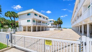 A gated entrance to a hotel with a warning sign, a clear sky, and a view of the ocean. - NEW! Beachfront 2BR + Pool + Walk to Beach (Indian Rocks Beach)
