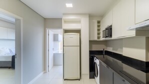 A modern kitchen with a refrigerator, microwave, and washing machine. - Fully Equipped apt in Downtown Floripa - Ejo0305 (Florianópolis)