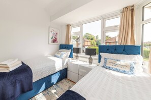 Une chambre avec deux lits, une fenêtre et une vue sur l’extérieur.