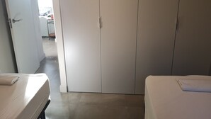 A room with a bed, a wardrobe, and a door leading to another room. - Atic Deluxe, excellent location (Barcelona)