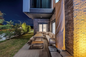 An outdoor patio with a sofa set, a wooden table, and a bench. - Luxury Forest Villas with Private Pool in ANTALYA (Antalya)