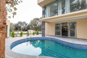 A modern house with a swimming pool, a glass door entrance, and a staircase leading to a balcony. - Forest Grove by Stayjade Poolbonfire 1hr E-city (Denkanikota)