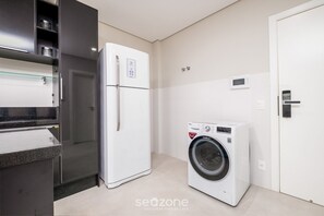 Eine kompakte Küche mit Kühlschrank, Waschmaschine und Backofen.