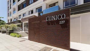 A modern building facade with a large sign reading "L'UNICO 227". - Modern Studio 4 Minutes From Jurere Beach Elu207 (Florianópolis)