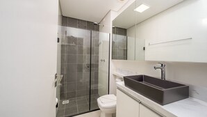 A modern bathroom with a glass-enclosed shower, a white toilet, and a large rectangular sink with a marble countertop. - Modern Studio 4 Minutes From Jurere Beach Elu207 (Florianópolis)
