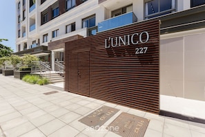 Facciata moderna di un edificio con un grande cartello che riporta la scritta "L'UNICO 227".