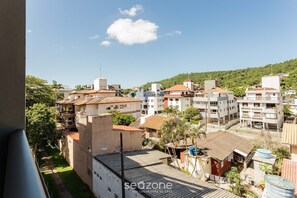 Zona residencial con edificios de varios pisos, algunos con balcones, y un paisaje montañoso de fondo.