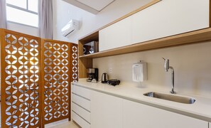 Una cocina moderna con un lavamanos integrado, una cafetera y un dispensador de agua.
