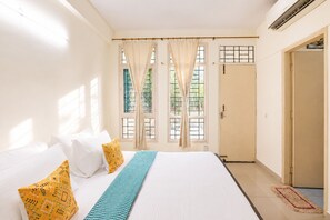 Ein Schlafzimmer mit einem Bett, Vorhängen, einem Fenster und einer Tür.