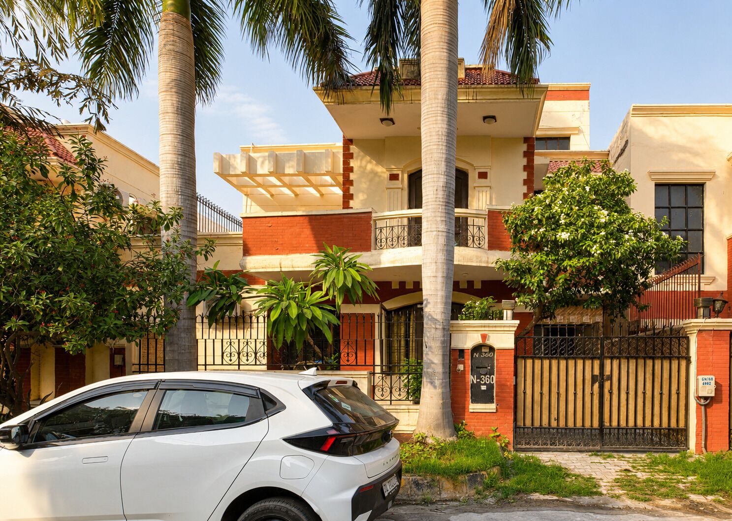 Un edificio residencial de varios pisos con un coche estacionado frente a él.
