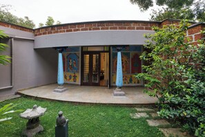 Un patio con pared de ladrillo, piso de baldosas y una estatua.