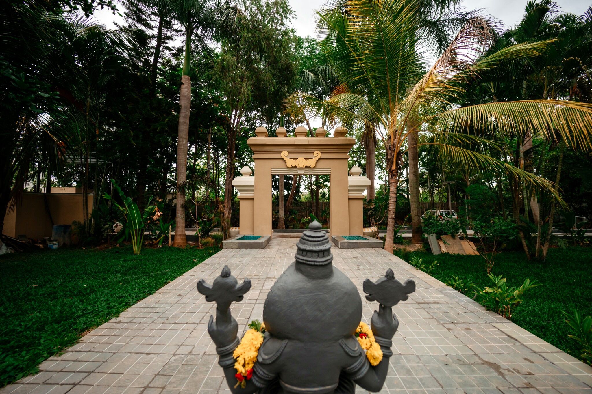 A pathway leading to a temple entrance with a statue at the end.