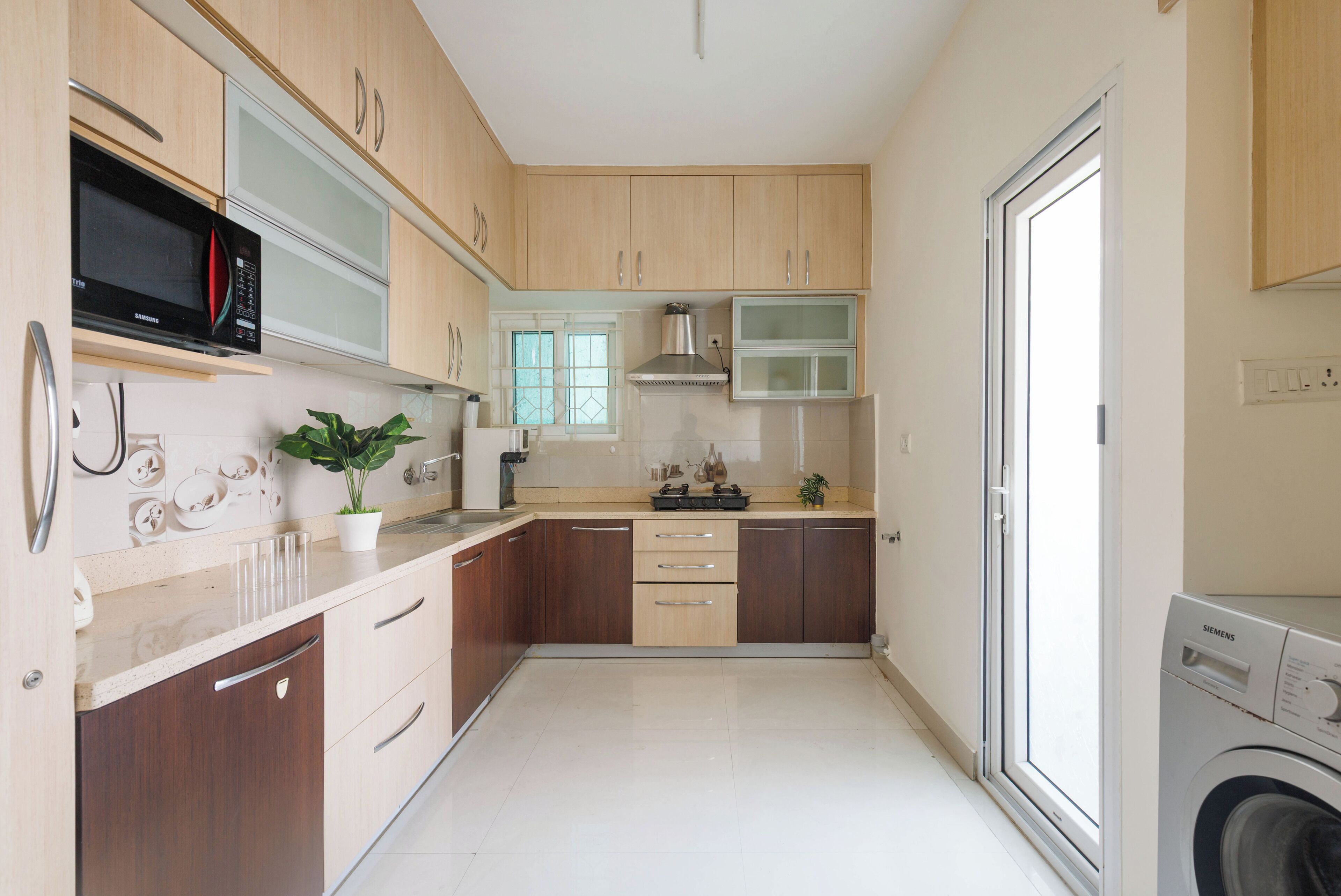 Una cocina moderna con armarios de madera, un microondas empotrado y un lavavajillas.