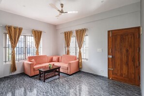 Ein Zimmer mit einer Couch, einem Couchtisch und einer Holztür.