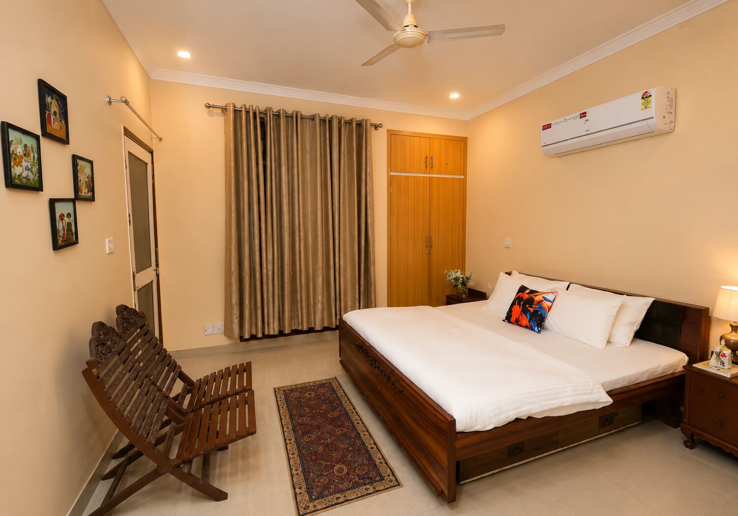 A bedroom with a bed, a wooden chair, a nightstand, a wall-mounted air conditioner, and a ceiling fan.