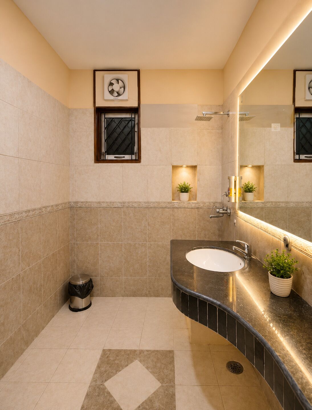 A modern bathroom with a curved sink, a mirror, and a potted plant.