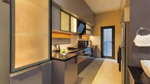 A modern kitchen with a refrigerator, stove, microwave, and a sink. - Orionrosewood Villa by Redolive3bhkacnr Airport (Bengaluru)