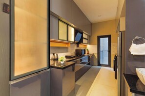 A modern kitchen with a refrigerator, stove, microwave, and a sink. - Orionrosewood Villa by Redolive3bhkacnr Airport (Bengaluru)
