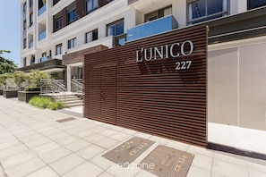 Fachada de um edifício moderno com uma grande placa com a inscrição 'L'UNICO 227'.