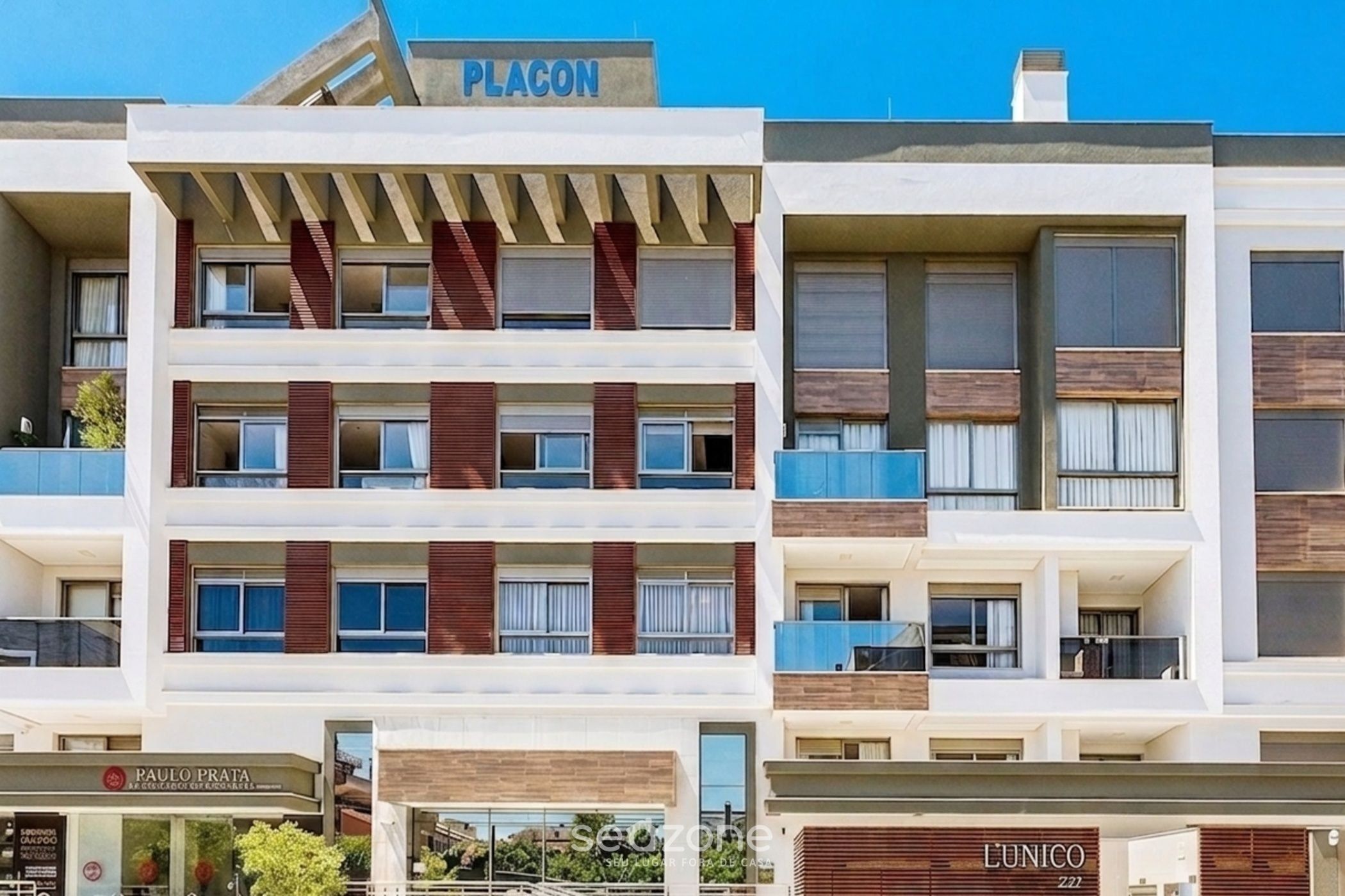 A multi-story hotel with a modern facade, balconies, and signage for 'PLAGON' and 'L'UNICO'.