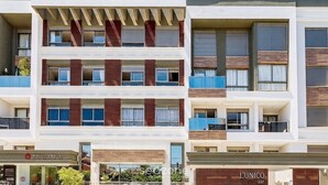 A multi-story hotel with a modern facade, balconies, and signage for 'PLAGON' and 'L'UNICO'. - Apt w/ Rooftop and Pool 300m From Beach Elu0211 (Florianópolis)