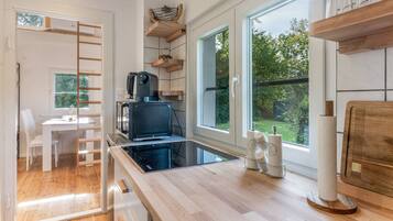 Een moderne keuken met een inbouwfornuis, een koffieapparaat en uitzicht op het buitengebied.
