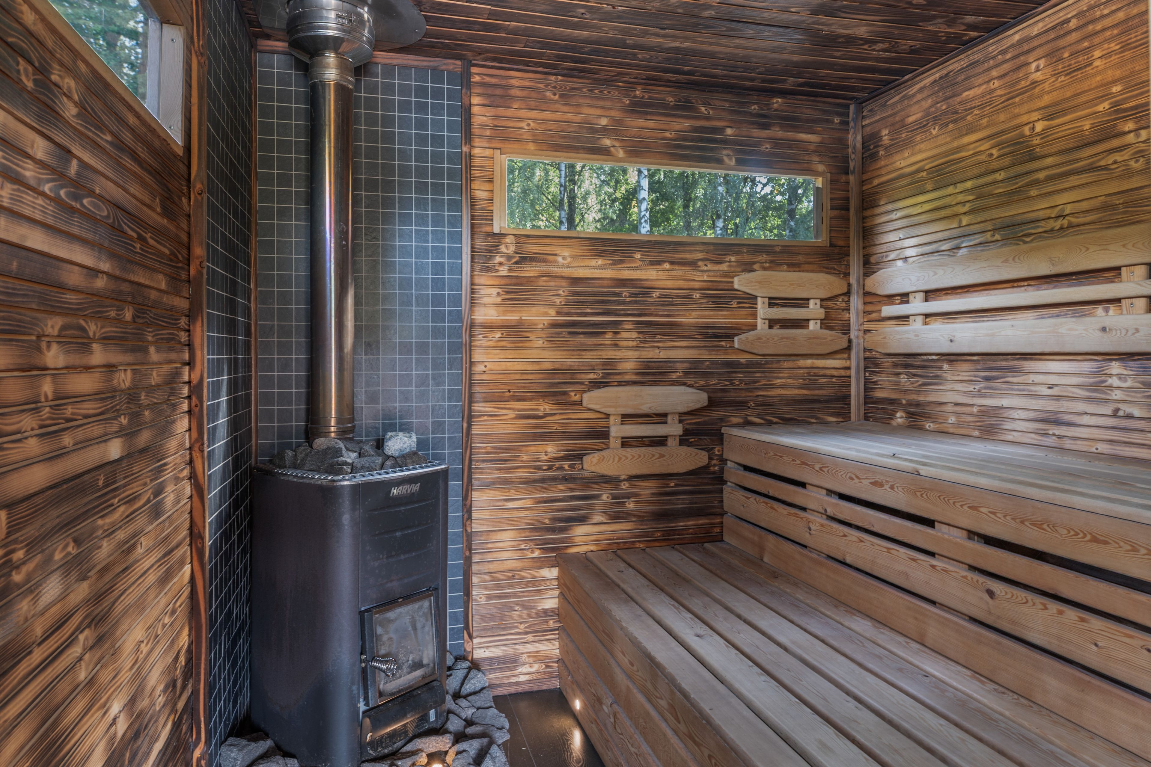 Ein Holzbadezimmer mit Kamin aus Stein und Bänken.