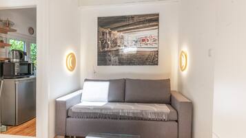 Ein modernes Wohnzimmer mit einem grauen Sofa, einem Couchtisch und einem Wandbild.