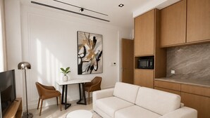 A modern living room with a sofa, a coffee table, a TV, and a painting on the wall.