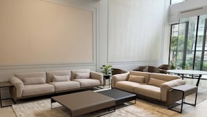 A modern living room with two sofas, a coffee table, and a dining table.