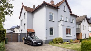Een tweelaags huis met een auto op de oprit.