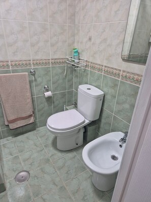 A bathroom with a toilet, bidet, and a towel rack. - 'Pausa Azul' Apartment with Sea Views, Wi-Fi, and Air Conditioning (Benalmádena)