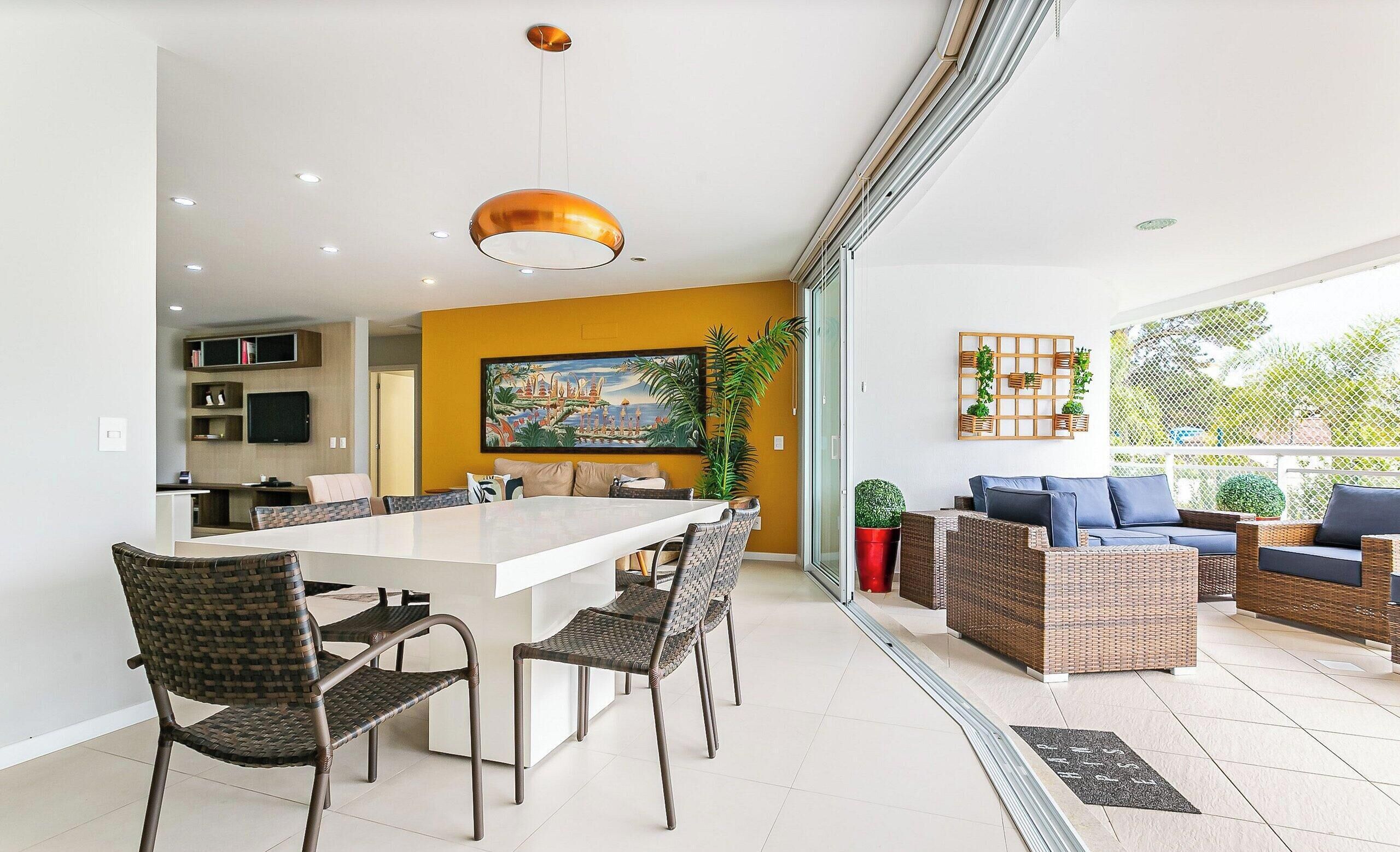 Un interior moderno con comedor, cocina y sala de estar, con un amplio ventanal.