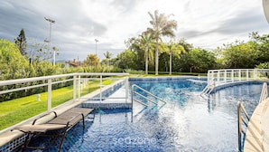 A swimming pool with a wooden deck, metal railings, and a white fence. - Ap in Resort 200m From the Beach Floripa-sc Mhe003 (Florianópolis)