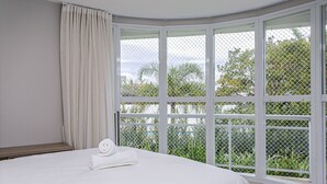 A bedroom with a large window, a bed, and a curtain. - Ap in Resort 200m From the Beach Floripa-sc Mhe003 (Florianópolis)