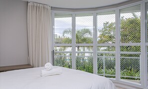 A bedroom with a large window, a bed, and a curtain. - Ap in Resort 200m From the Beach Floripa-sc Mhe003 (Florianópolis)
